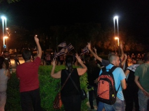 Palestinians raise their hands in victory sign against right wing demo in Haifa